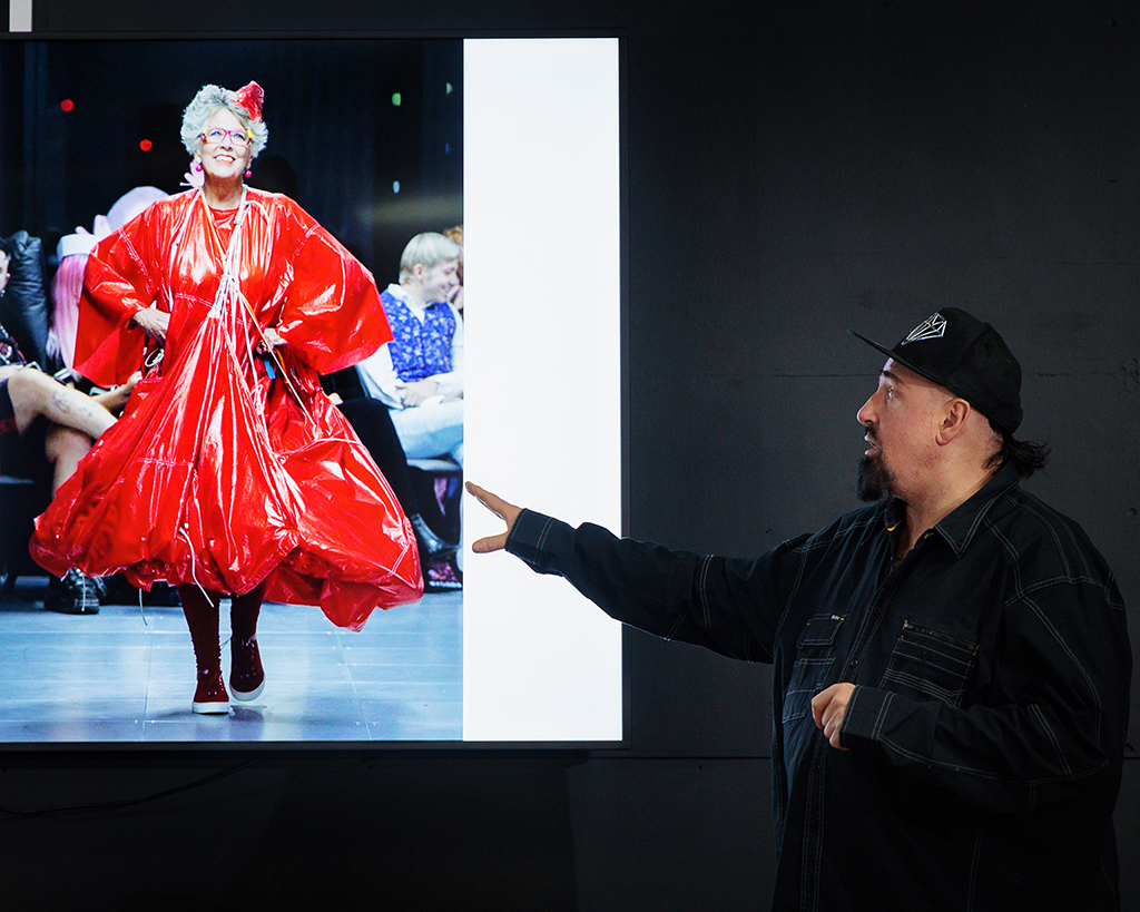 Here, VIN + OMI show the gathered audience a striking red garment, created from a repurposed parachute, which was featured as the London Fashion Week's grand finale, attracting worldwide attention from leading media outlets.